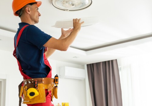 An,Electrician,Installs,A,Chandelier,On,The,Ceiling.,Hands,Of